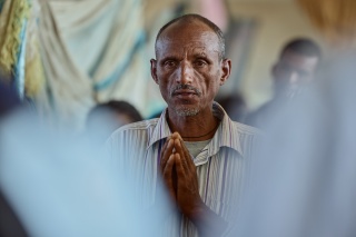 Berhan Haileselassie pictured with his hands clasped together in prayer.